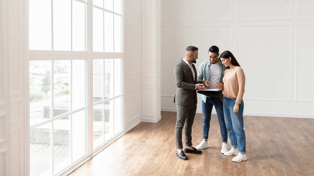 A man giving a couple a tour of an apartment. 