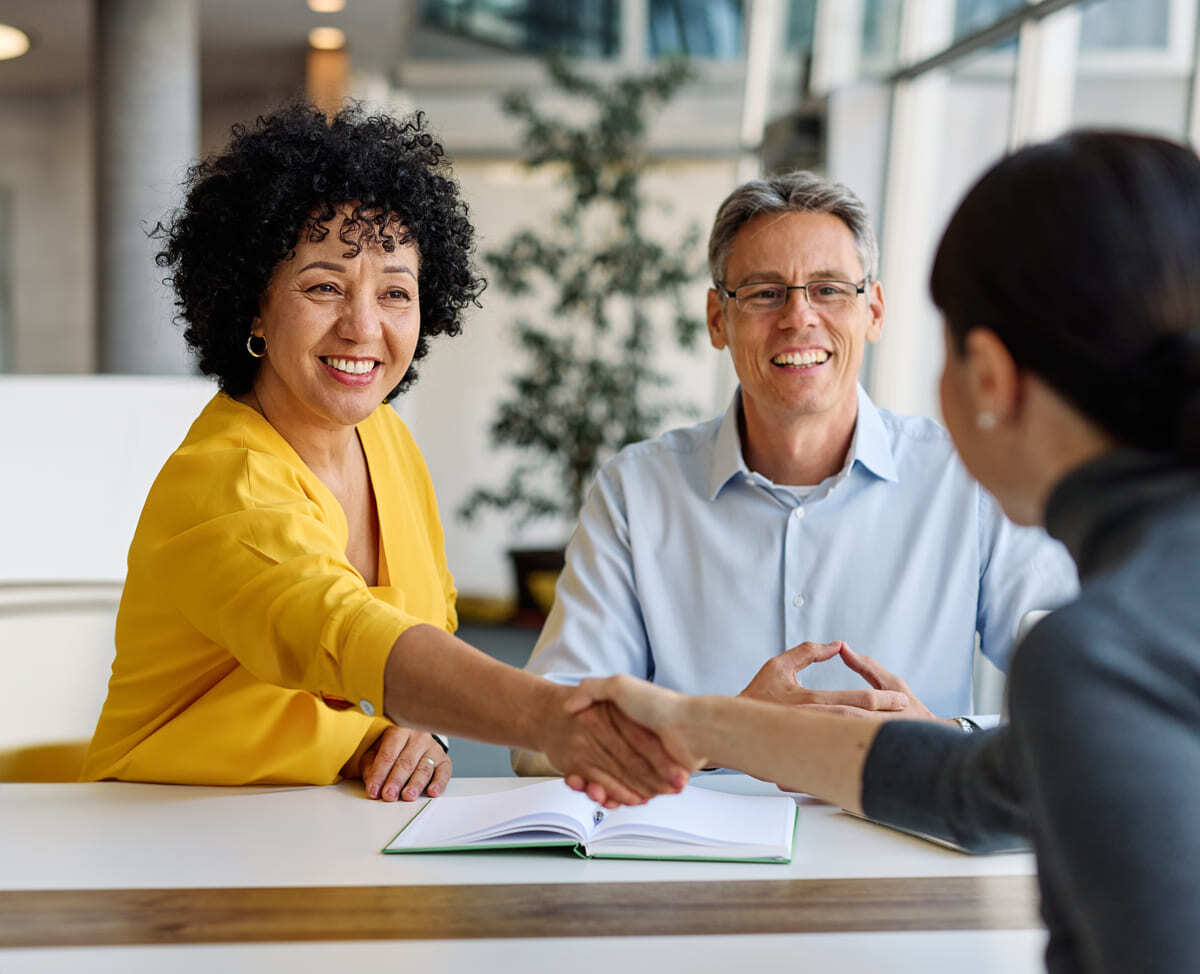 Two people shaking hands during a rental negotiation.