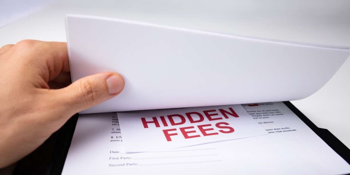 A hand finds Hidden Fees underneath papers