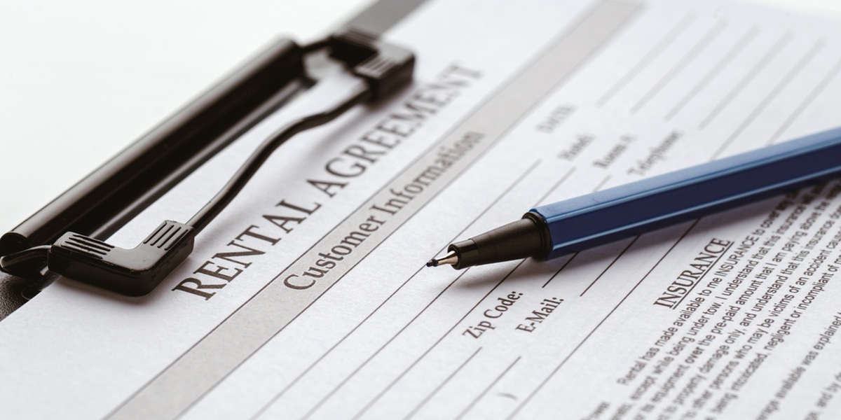 A lease agreement on a clipboard with a pen on top