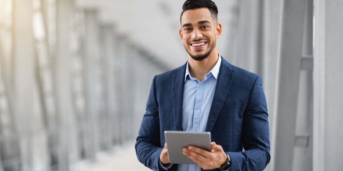 A man smiling with a tablet - peace of mind - featured_image