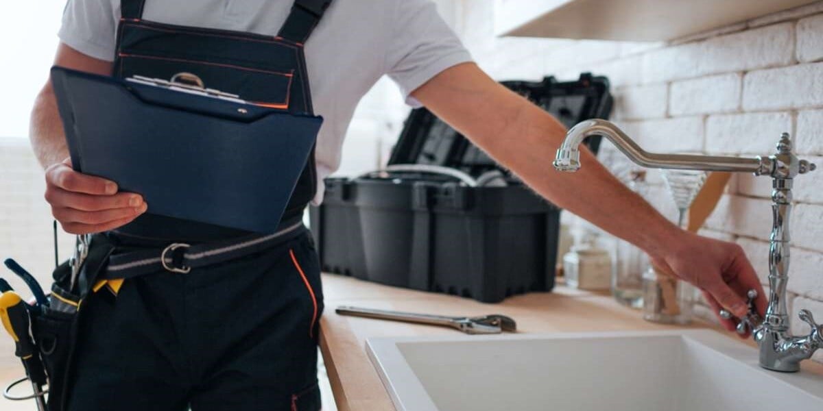 A plumber fixes a leaky sink in a rental home