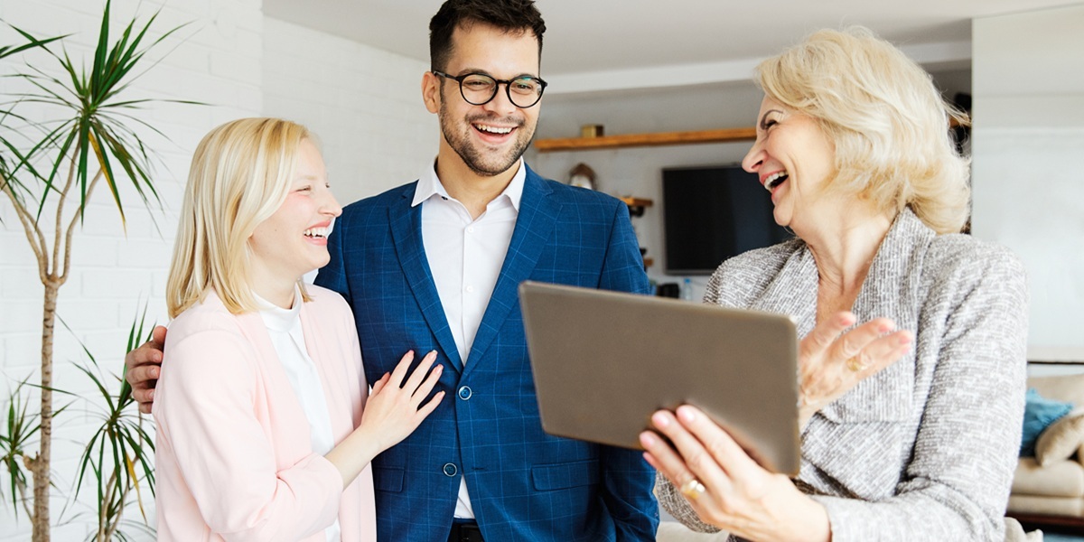 Female property manager laughing with male and female rental property owners