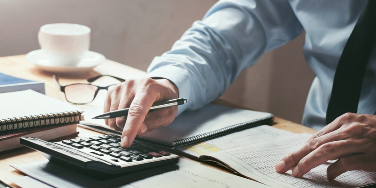 man typing on a calculator